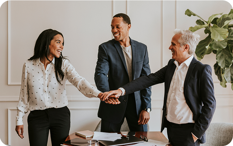 Three business people with their hands together