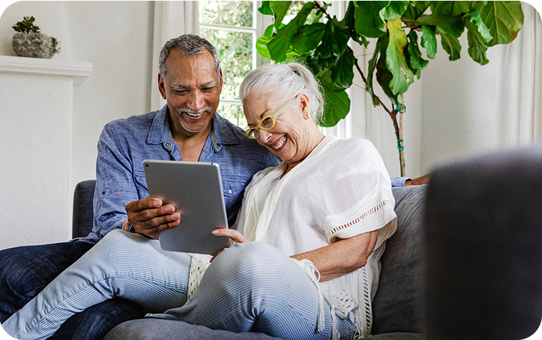 Older couple on couch viewing tablet