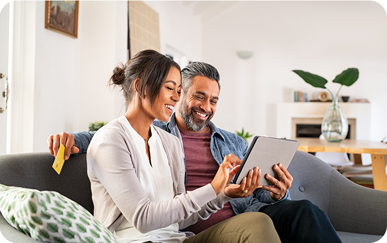 Couple on couch looking at tablet