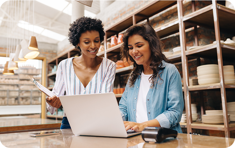 Two women owners in their shop looking at laptop