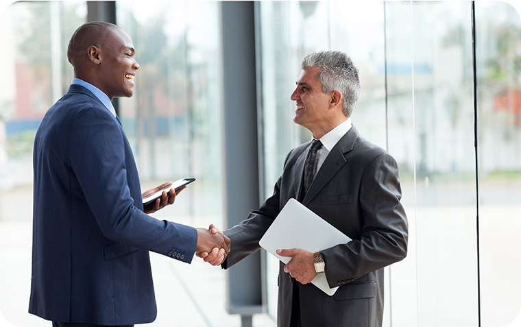 Two businessmen shaking hands in corporate office