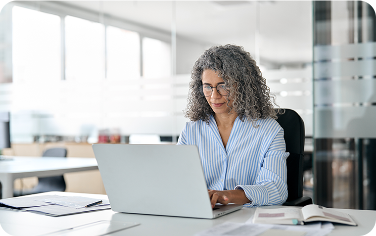 Business woman on laptop at desk in office