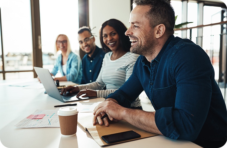 Four young businesspeople sitting at meeting table